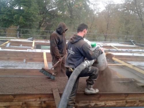 Substrate is blown onto the roof from a silo truck